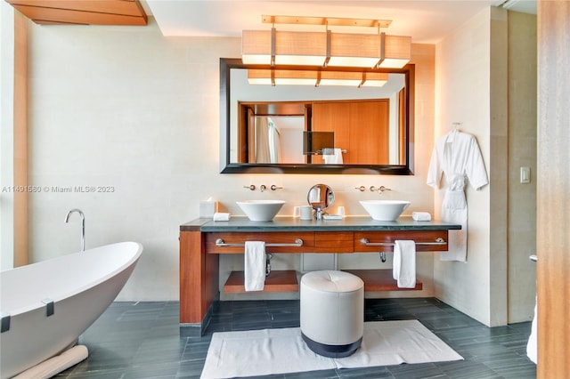 bathroom featuring large vanity, dual sinks, a washtub, and tile flooring