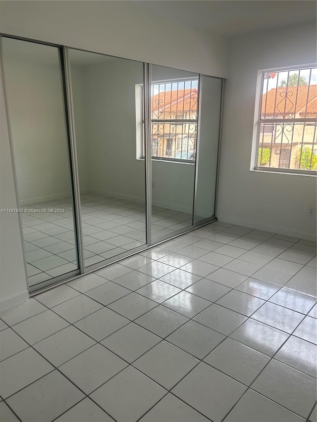 unfurnished bedroom featuring a closet and light tile flooring