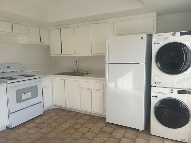 interior space with stacked washer / dryer, white appliances, white cabinetry, and sink