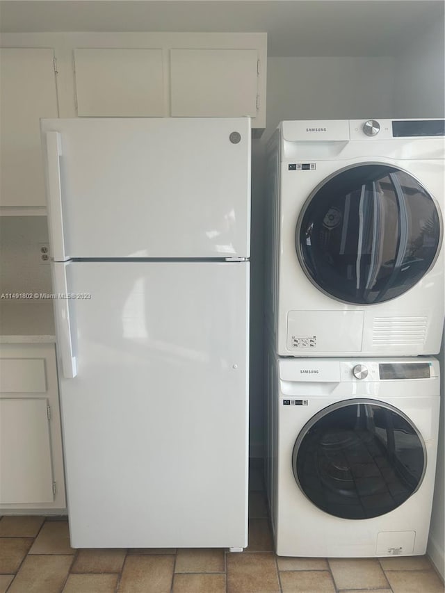 laundry area with stacked washer / dryer and light tile flooring