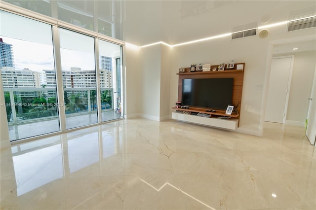 unfurnished living room featuring floor to ceiling windows and light tile floors