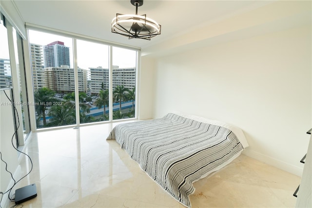 bedroom featuring light tile floors, floor to ceiling windows, and a chandelier