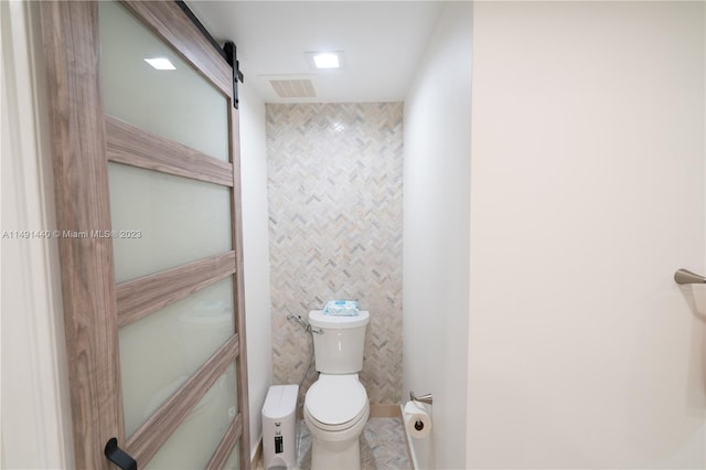 bathroom featuring tile walls and toilet