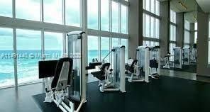 gym with a water view and a wall of windows