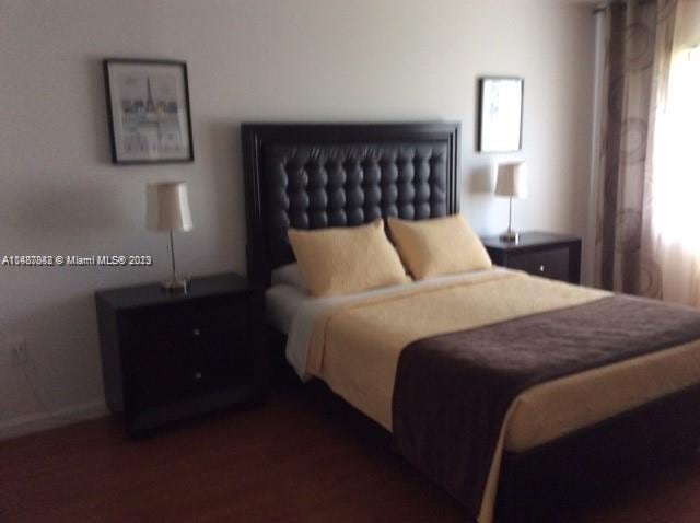 bedroom with dark wood-type flooring