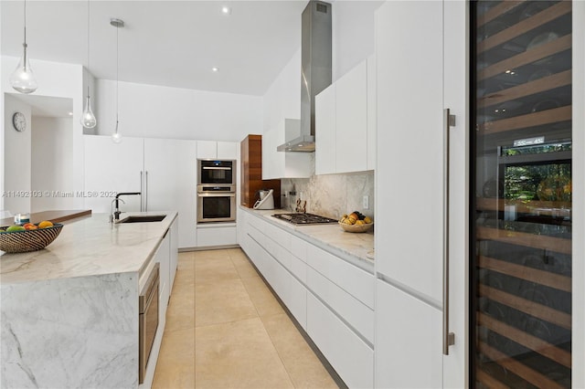 kitchen with sink, white cabinets, wall chimney range hood, tasteful backsplash, and pendant lighting