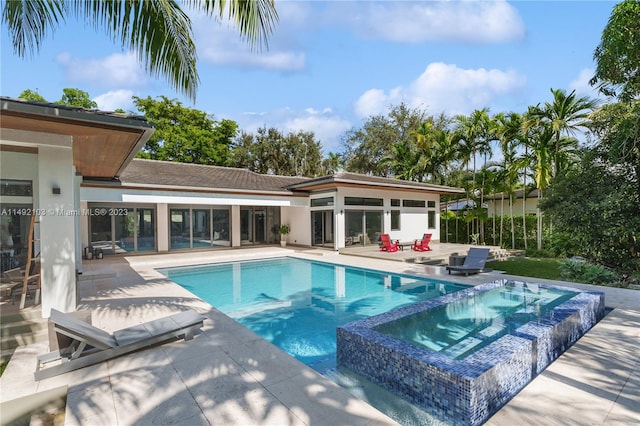 view of pool with a patio area and an in ground hot tub