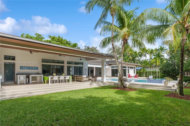 back of house featuring ceiling fan, a lawn, and a patio