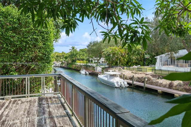 wooden deck featuring a dock and a water view