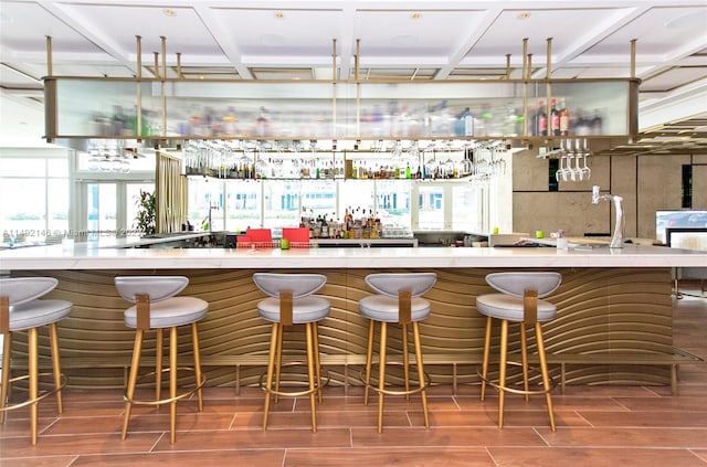 bar with coffered ceiling and a wealth of natural light