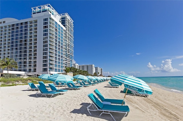 view of property's community with a water view and a view of the beach