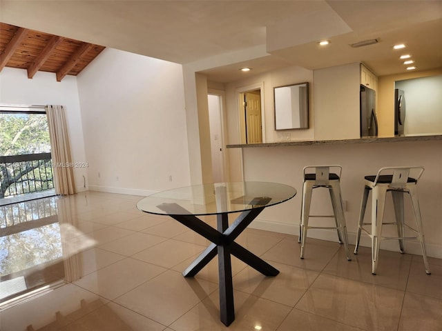 unfurnished dining area with light tile floors, vaulted ceiling with beams, and wood ceiling