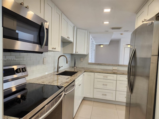 kitchen featuring sink, light tile floors, stainless steel appliances, light stone countertops, and tasteful backsplash