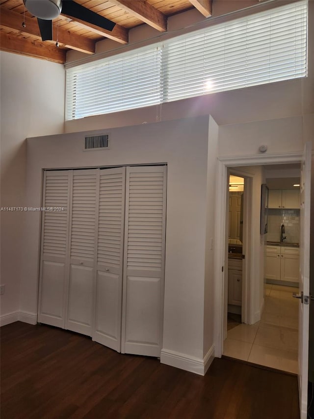 interior space featuring sink, dark wood-type flooring, wood ceiling, and beamed ceiling