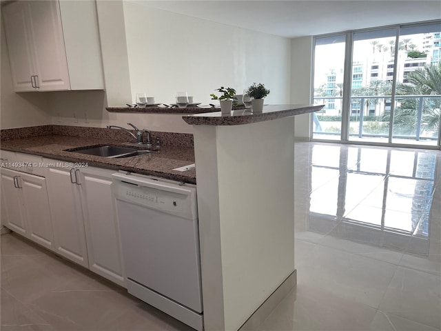 kitchen featuring light tile flooring, white cabinetry, a wealth of natural light, and dishwasher