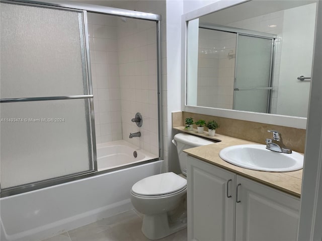 full bathroom featuring vanity, combined bath / shower with glass door, tile flooring, and toilet