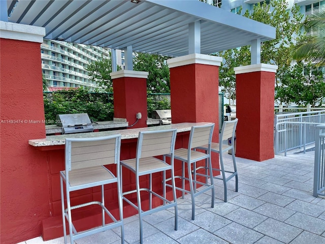 view of patio / terrace featuring exterior kitchen and a grill