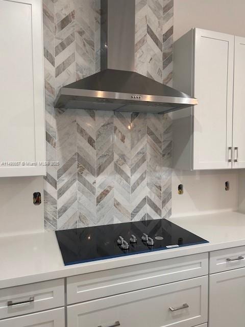 kitchen featuring white cabinets, light countertops, and wall chimney range hood