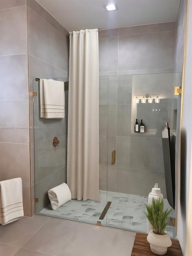 bathroom featuring tile walls and a stall shower