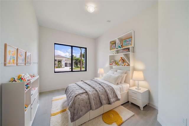 bedroom with light wood-type flooring and baseboards