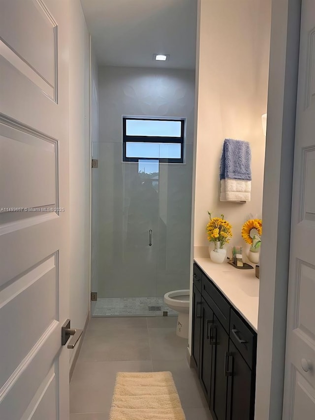 bathroom featuring toilet, a stall shower, vanity, and tile patterned flooring