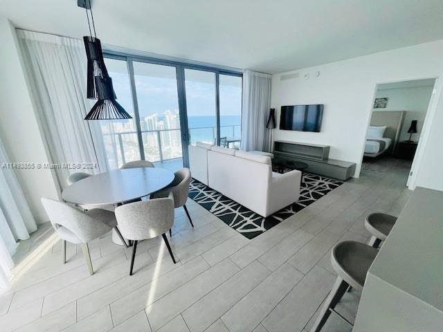 living room featuring floor to ceiling windows and a water view