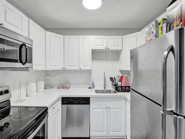 kitchen with white cabinets, tasteful backsplash, stainless steel appliances, and sink