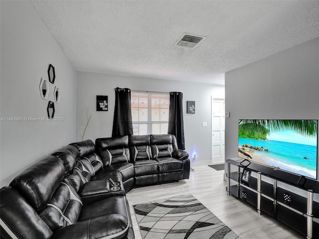 living room featuring a textured ceiling and light wood-type flooring