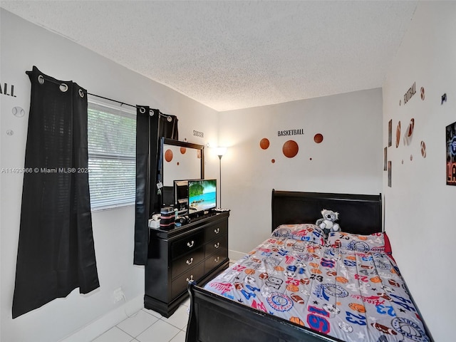 bedroom with light tile floors and a textured ceiling