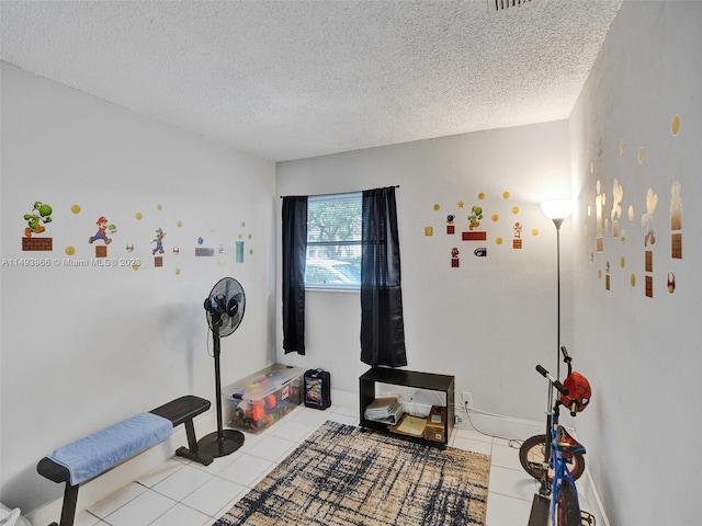 misc room with a textured ceiling and light tile floors