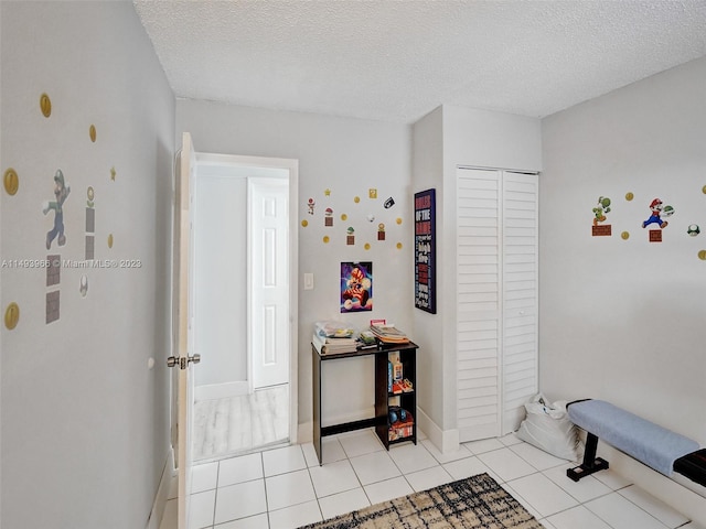 interior space featuring a textured ceiling and light tile flooring