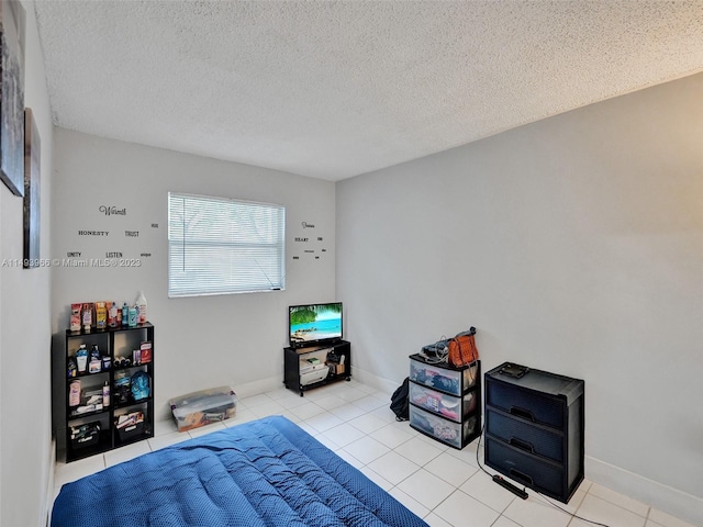 bedroom with a textured ceiling and light tile flooring