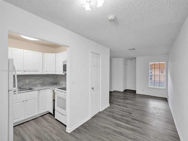 kitchen with white cabinetry, backsplash, dark hardwood / wood-style floors, white appliances, and sink