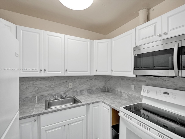 kitchen with tasteful backsplash, white appliances, white cabinetry, and sink