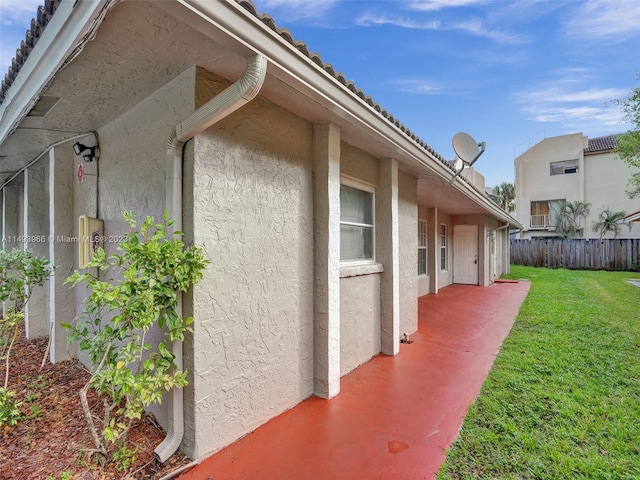 view of side of property featuring a yard and a patio area