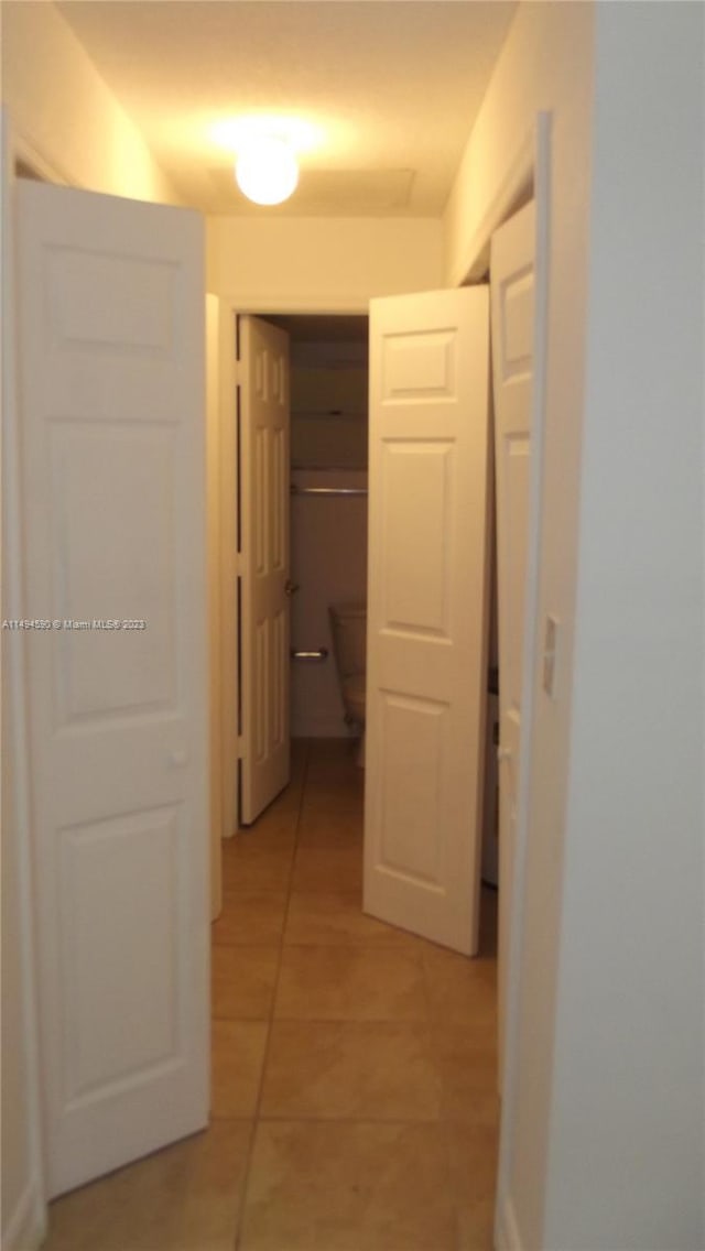 hall featuring light tile patterned floors