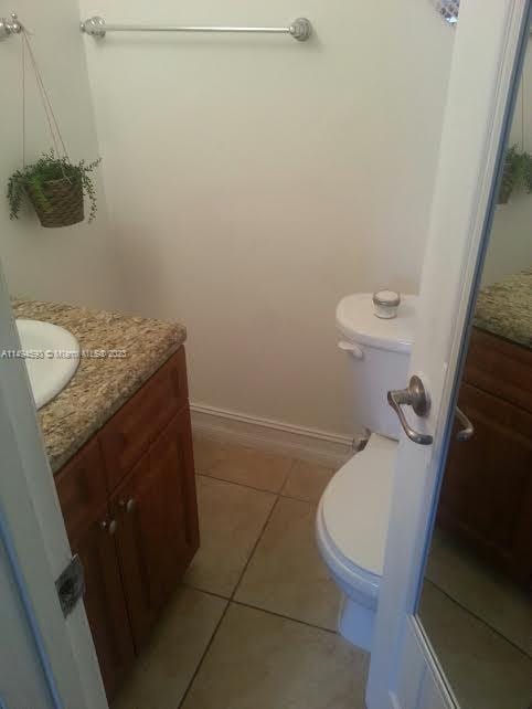 bathroom featuring tile patterned flooring, vanity, and toilet