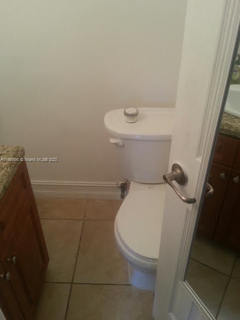 bathroom with tile patterned flooring, vanity, and toilet