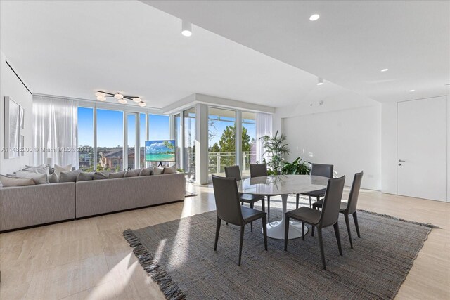 dining area with light hardwood / wood-style floors and a wall of windows