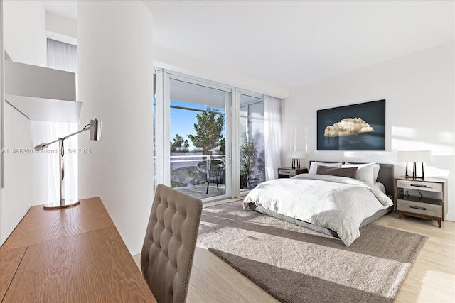 bedroom with access to exterior and light wood-type flooring