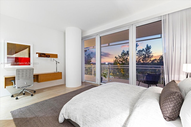 bedroom featuring access to exterior and light wood-type flooring