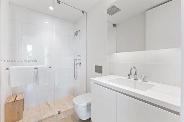 bathroom with a shower with door, toilet, and vanity