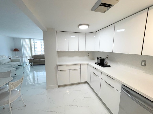 kitchen featuring stainless steel dishwasher, white cabinetry, expansive windows, and light tile patterned floors