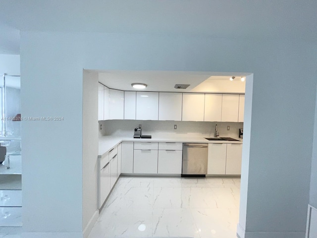 kitchen with light tile patterned flooring, white cabinets, dishwasher, backsplash, and sink