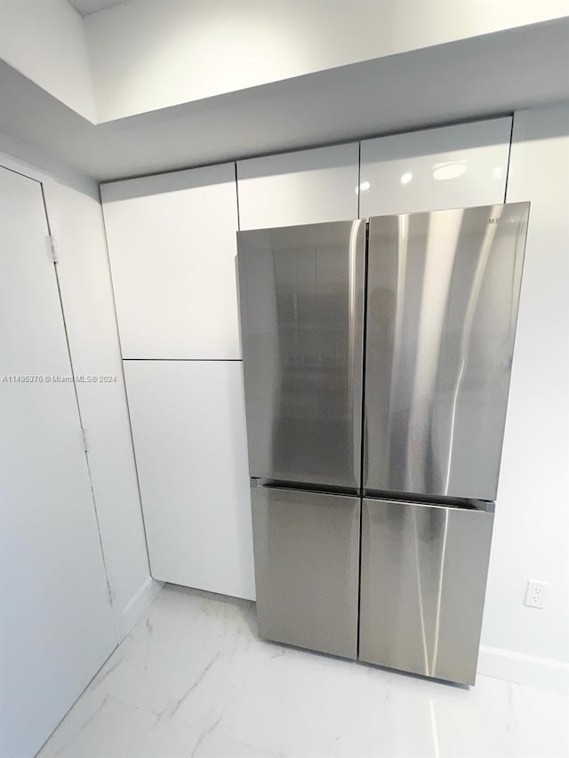 room details with white cabinetry and stainless steel fridge