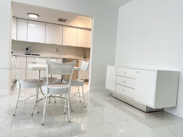 unfurnished dining area with light tile patterned flooring and sink