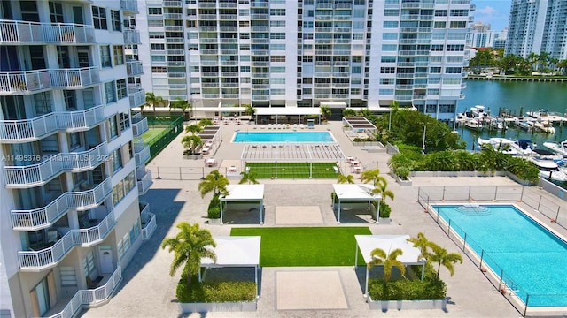 view of swimming pool featuring a patio and a water view