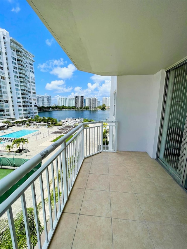 balcony with a water view and a community pool