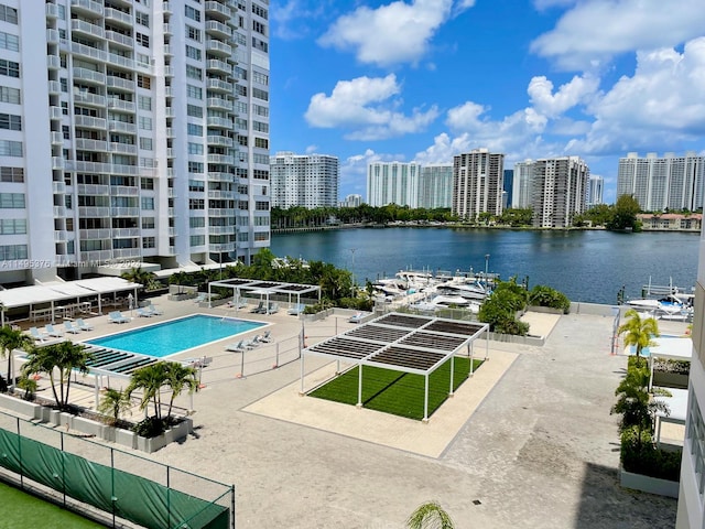 view of swimming pool featuring a patio and a water view