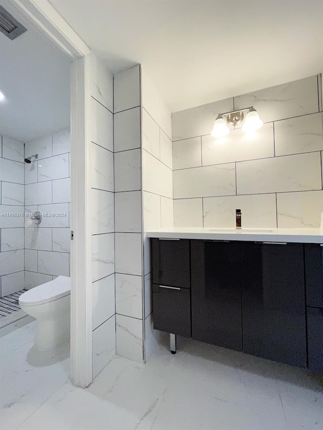 bathroom featuring a shower, vanity, tile patterned flooring, and toilet